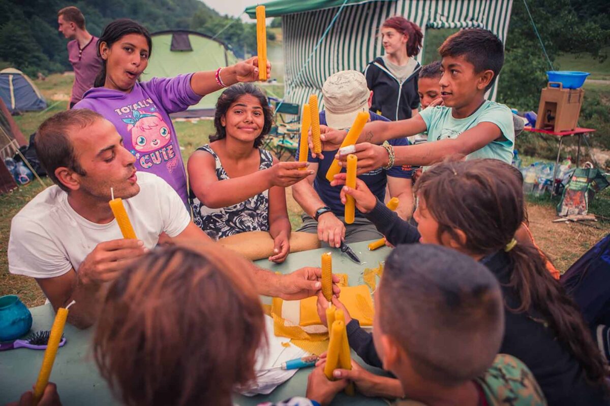 Izidor at LLR camp with kids making candles