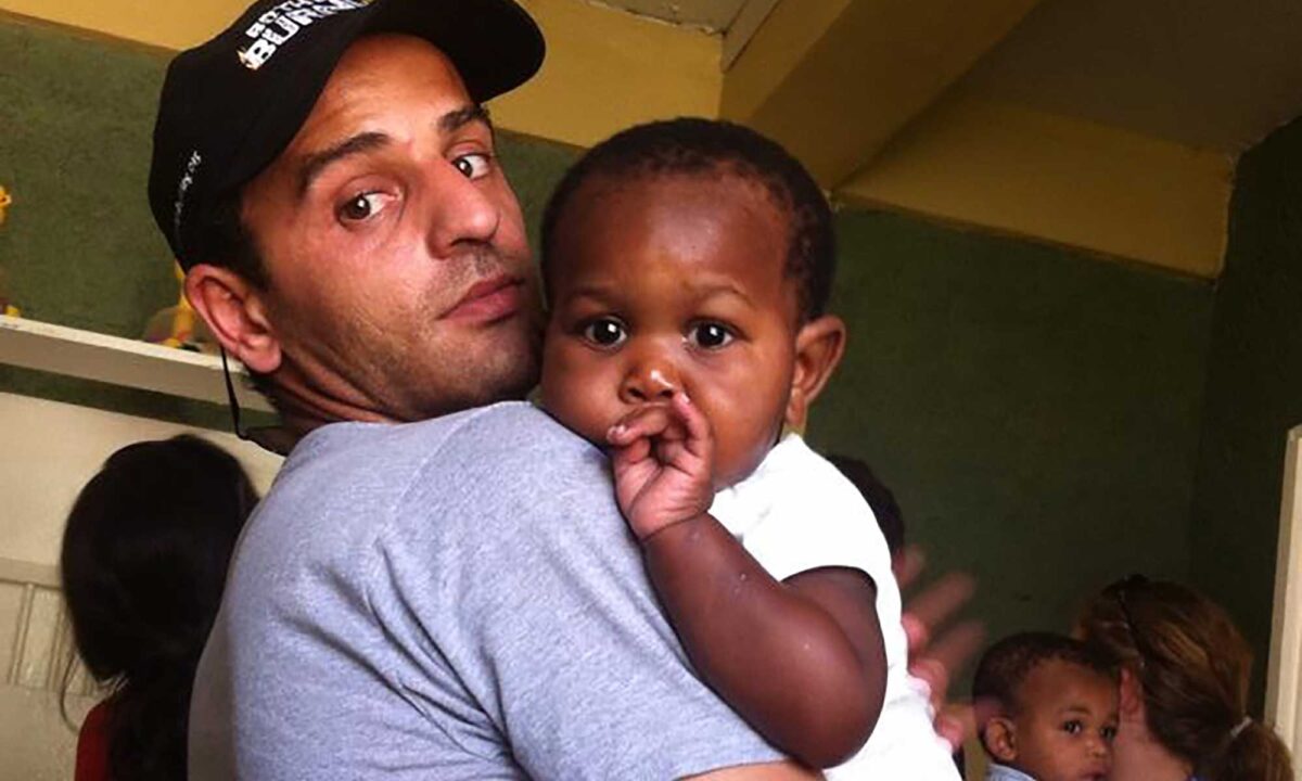 Izidor in Haiti, holding orphan child