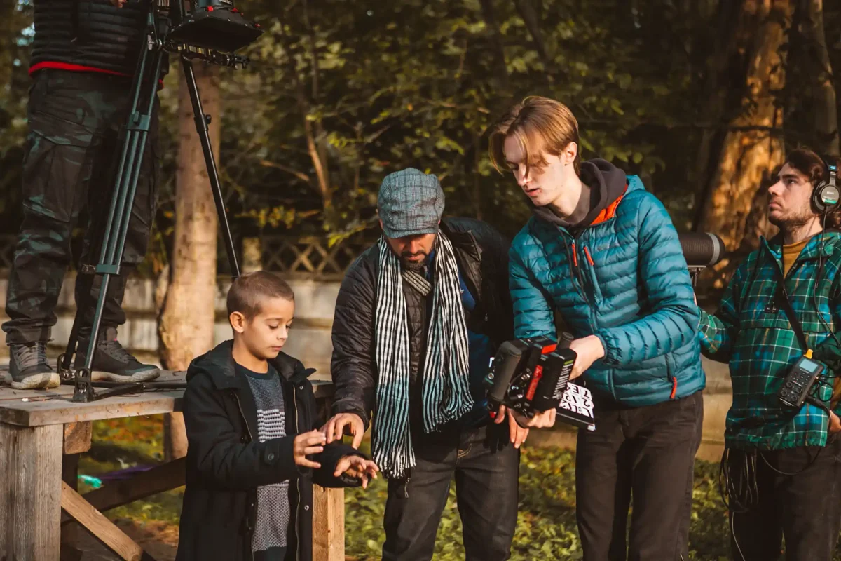 Location shoot, Director reviewing shot with young Izidor and crew